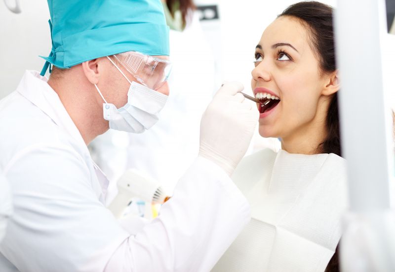 Dentysta sprawdza zęby kobiecie 